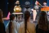 Vier Kidner stehen vor den Figuren des Triadischen Balletts von Oskar Schlemmer, man sieht ihre Rücken.